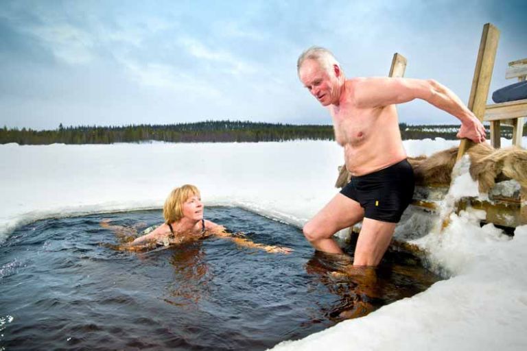 真冬、凍った湖の氷に穴を開け、湖に浸かる